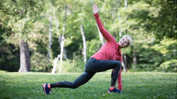 Astrid trener yoga i en park