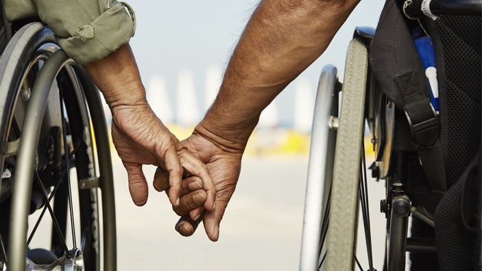 Par i rullestol holder hender